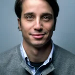 Young man with serious expression against a neutral background